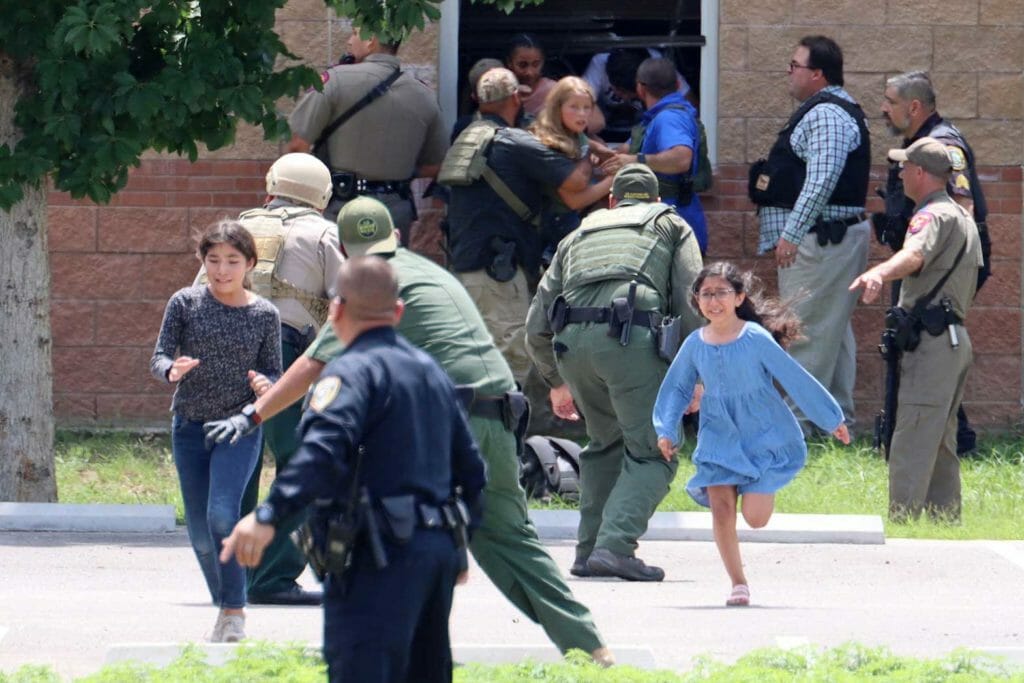 Children run to safety after escaping from a window during a mass shooting at Robb Elementary School where a gunman killed nineteen children and two adults in Uvalde, Texas, U.S. May 24, 2022. Picture taken May 24, 2022. Pete Luna/Uvalde Leader/REUTERS
