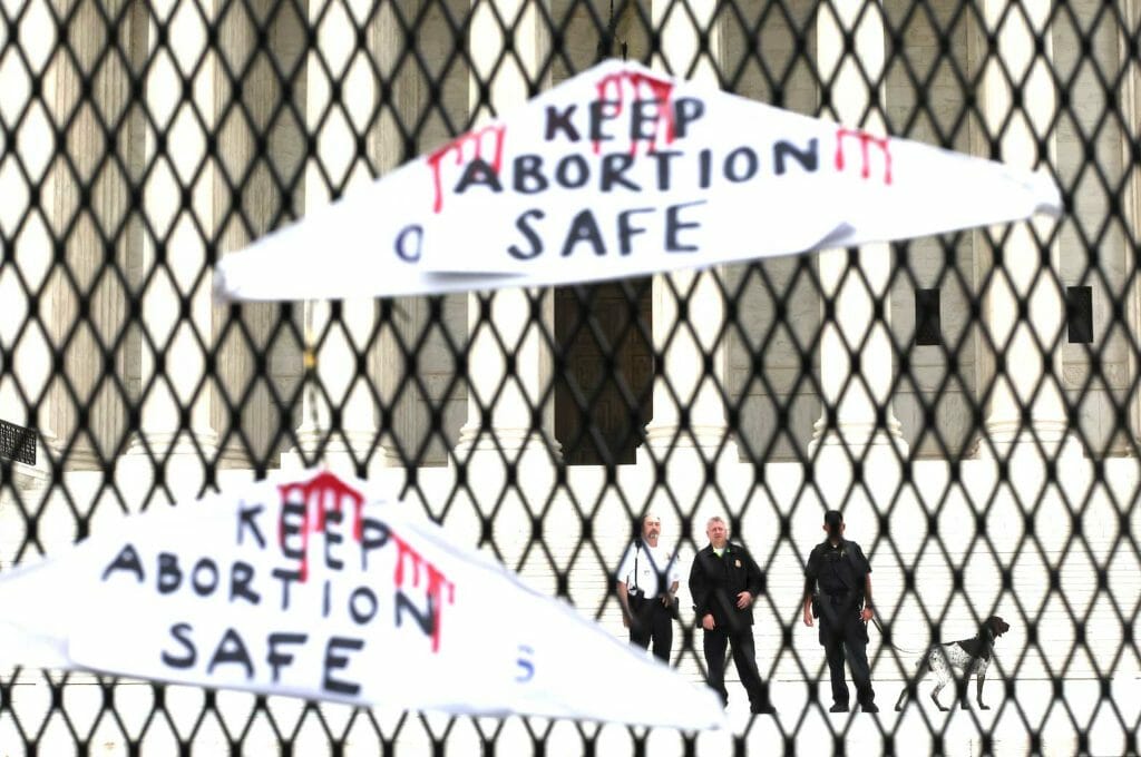 Law enforcement watch as people rally for abortion rights after an anti-climb protective fence was installed outside of the U.S. Supreme Court building in Washington, U.S., May 5, 2022. REUTERS/Leah Millis