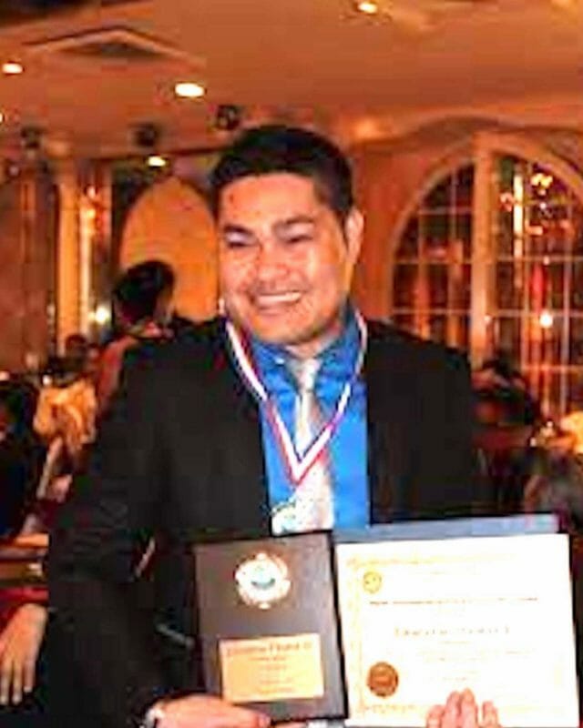 Ely Timbal holding a previous award from by the Association of Filipino Teachers in America. He was just named one of  the 54 best teachers in New York by Gov. Hochul.