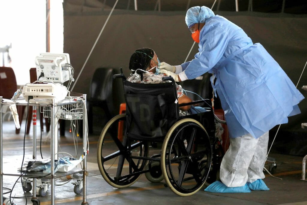  A health care worker tends to a patient at a temporary ward set up during the coronavirus disease (COVID-19) outbreak, at Steve Biko Academic Hospital in Pretoria, South Africa, January 19, 2021. Phill Magakoe/Pool via REUTERS/File Photo