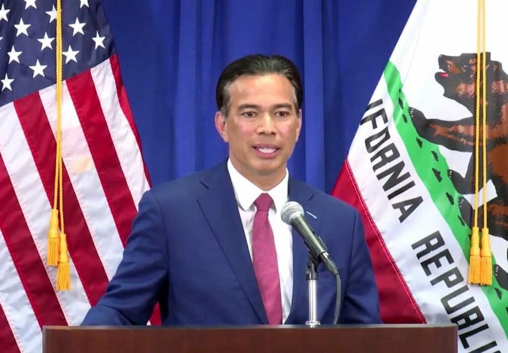 Rob Bonta at podium with US and California flags in the background