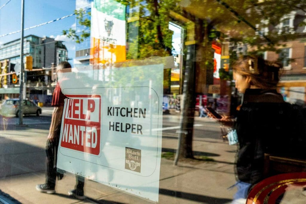 A help wanted sign hangs in a bar window along Queen Street West in Toronto Ontario, Canada June 10, 2022. REUTERS/Carlos Osorio/File Photo