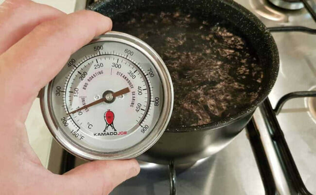 This is a meat thermometer on a pot of boiling water.