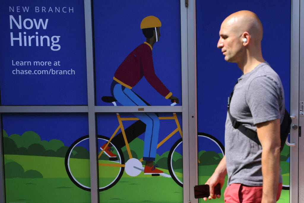 A pedestrian passes a "Now Hiring" sign at a Chase Bank branch in Somerville, Massachusetts, U.S., September 1, 2022. REUTERS/Brian Snyder