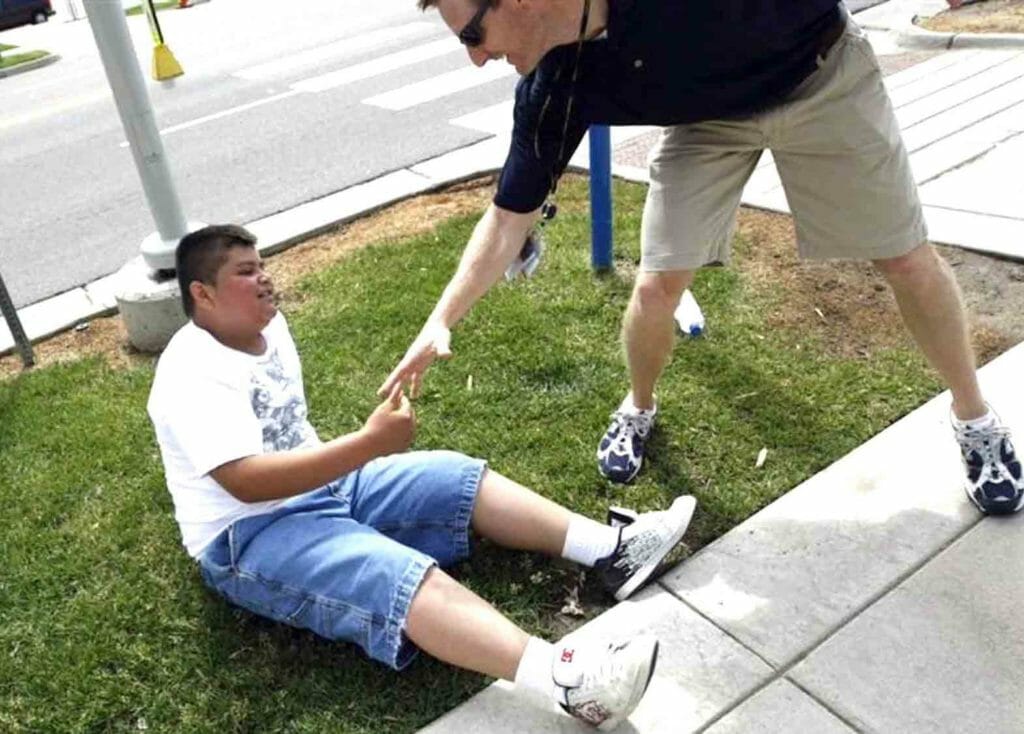 Hiro Mejia (L), a patient in the metabolic syndrome clinic, is helped up by Michael Witten, director of the Wellness Center at the annual run/walk for patients and their friends and families at The Children's Hospital in Aurora, Colorado June 5, 2010. REUTERS/Rick Wilking