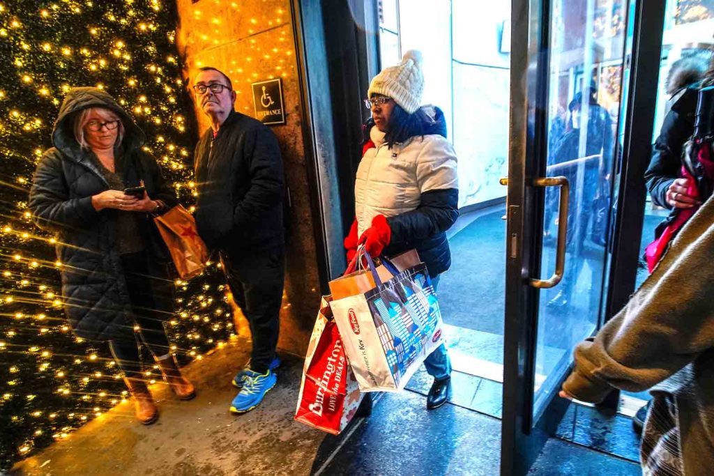 People carrying shopping bags exit a retail store during the holiday season in New York City, U.S., December 15, 2022. REUTERS/Eduardo Munoz
