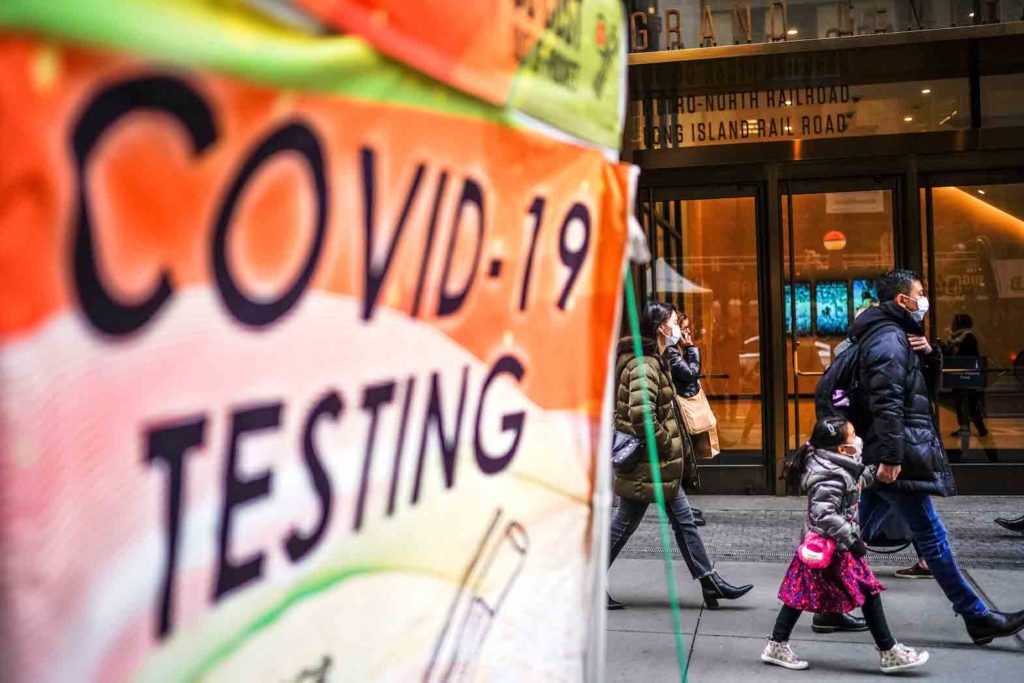 People wearing masks walk next to coronavirus disease (COVID-19) testing site in New York City, New York, U.S., December 12, 2022. REUTERS/Eduardo Munoz