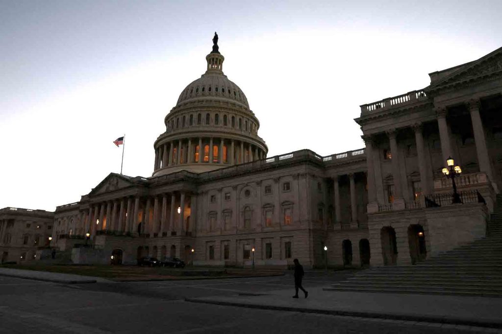 A person walks past the U.S. Capitol building at sunset as the Republican-controlled House of Representatives reconvenes on Capitol Hill in Washington, U.S., January 9, 2023. REUTERS/Leah Millis/File Photo 