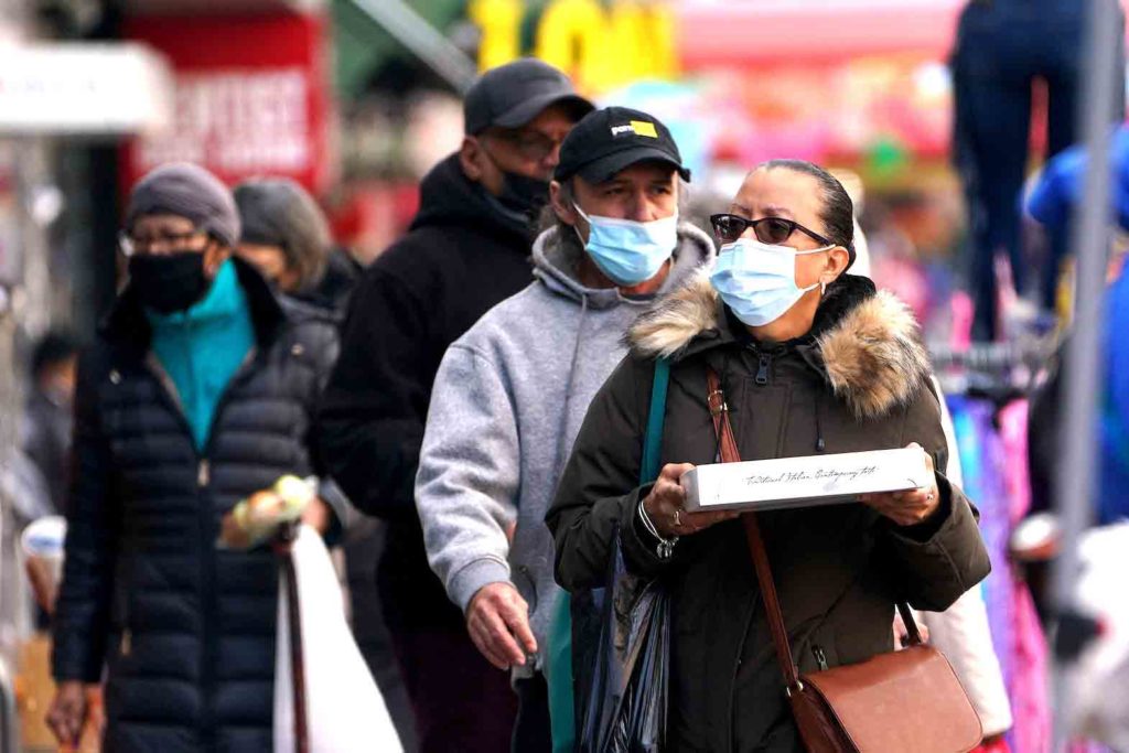 People walk outside wearing masks during the coronavirus disease (COVID-19) pandemic in the Harlem area of the Manhattan borough of New York City, New York, U.S., February 10, 2022. REUTERS/Carlo Allegri
