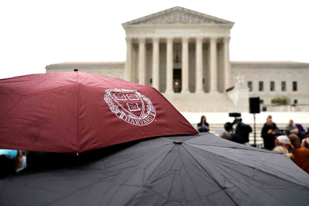 A person holds an umbrella with a Harvard logo print as demonstrators gather in support of affirmative action, as the U.S. Supreme Court is set to consider whether colleges may continue to use race as a factor in student admissions in two cases, at the U.S. Supreme Court building in Washington, U.S. October 31, 2022. REUTERS/Jonathan Ernst