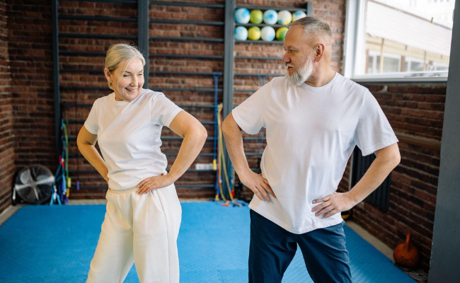 Older couple working out wearing oversized workout shirts