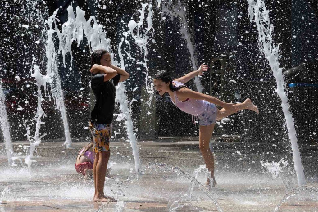 Sisters Olivia, 10, and Evelyn Black, 12, play in Gateway Fountains at Discovery Green park to escape the hot weather in Houston, Texas, U.S., July 18, 2023. REUTERS/Adrees Latif