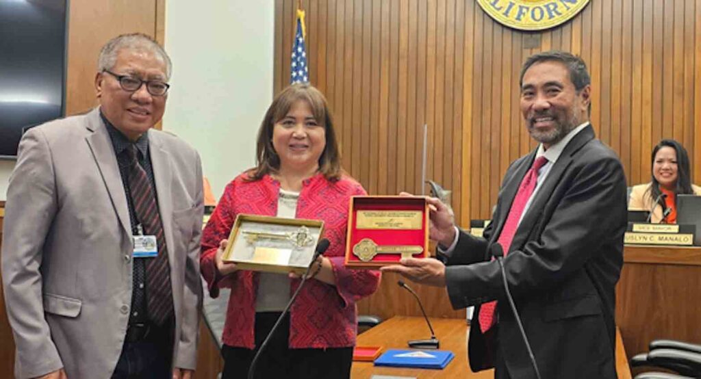 Quezon City Councilor Marra Suntay (center-left), representative of Mayor Joy Belmonte, takes part in the exchange of ceremonial keys with Daly City, California Mayor Ray Buenaventura during the regular session of the Daly City Council on 10 July 2023. Also in the photo are Quezon City Planning and Development Department Head Pedro Rodriguez (left), and Daly City Vice Mayor Juslyn Manalo (right, seated). CONTRIBUTED