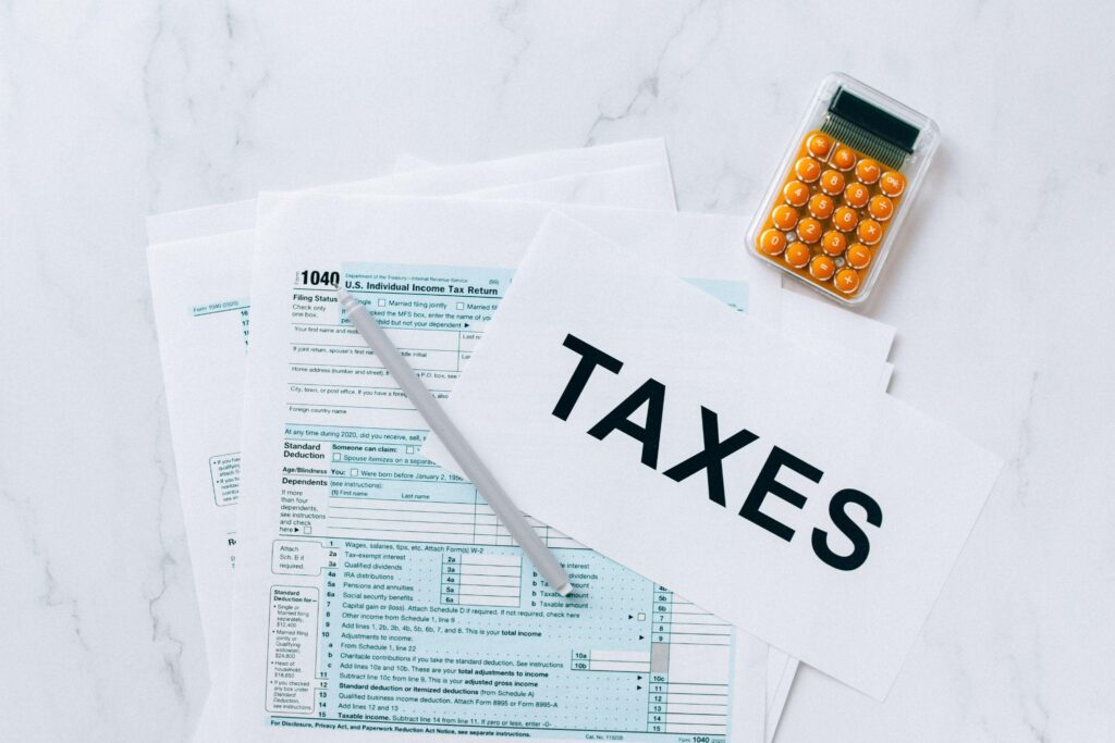Taxes, calculator, pen, and tax forms on white background