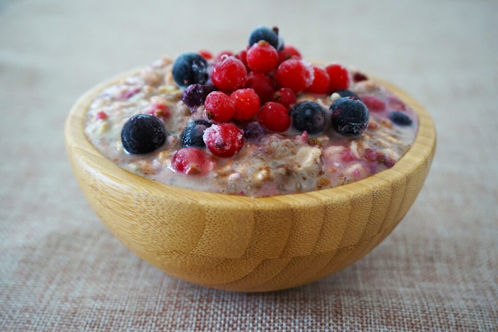 Oatmeal in wooden bowl with assorted berries