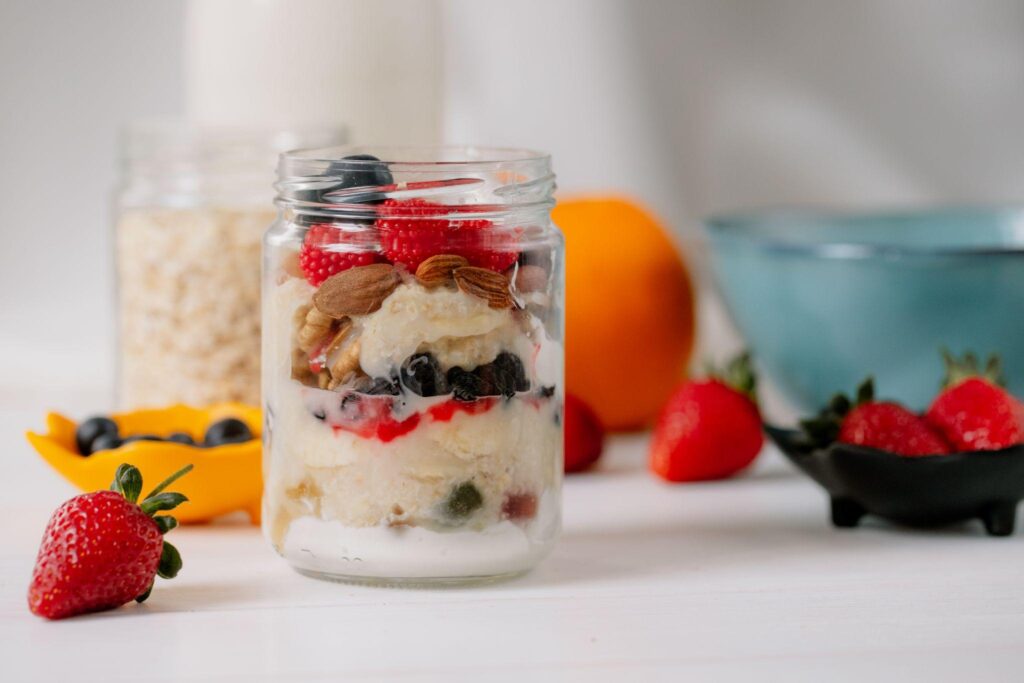 Overnight oats in glass jar on white surface with assorted ingredients