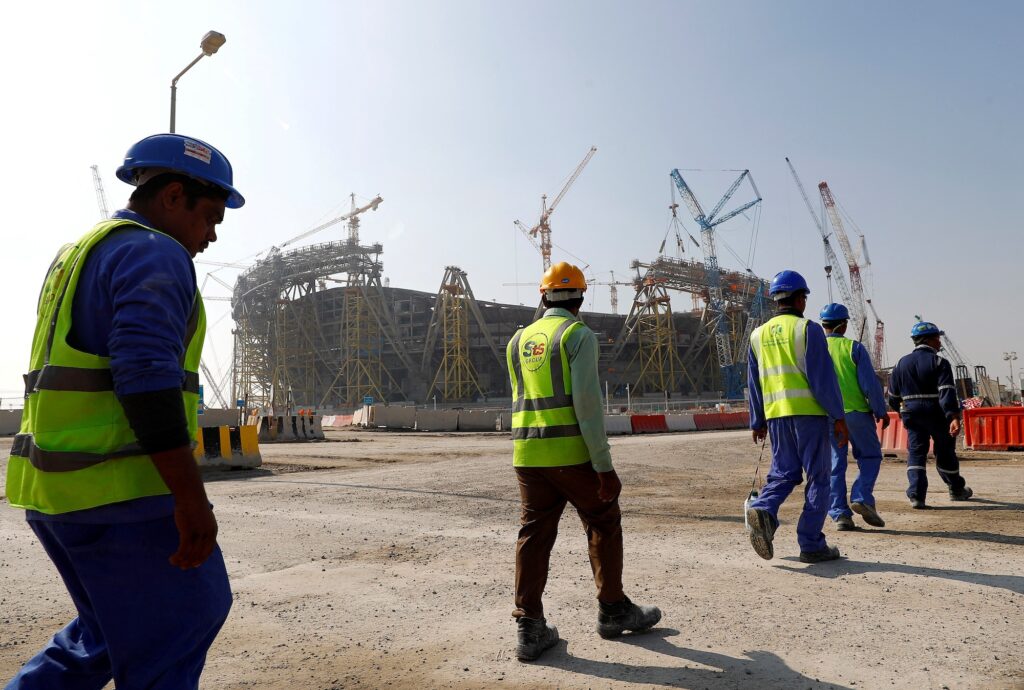 FILE PHOTO: Workers walk towards the construction site of the Lusail stadium which will be build for the upcoming 2022 Fifa soccer World Cup during a stadium tour in Doha, Qatar, December 20, 2019. REUTERS/Kai Pfaffenbach/File Photo