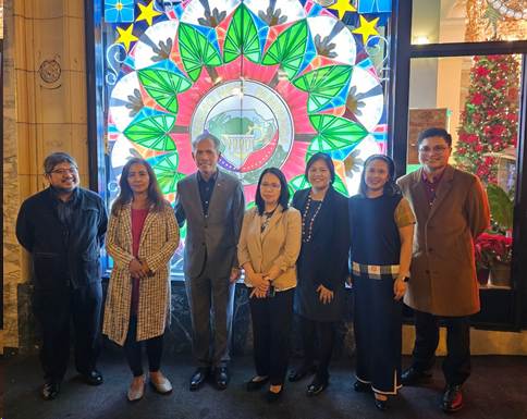 Consulate officials pose in front of the giant parol