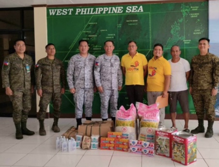 Volunteers pose with soldiers with relief goods and Christmas gifts