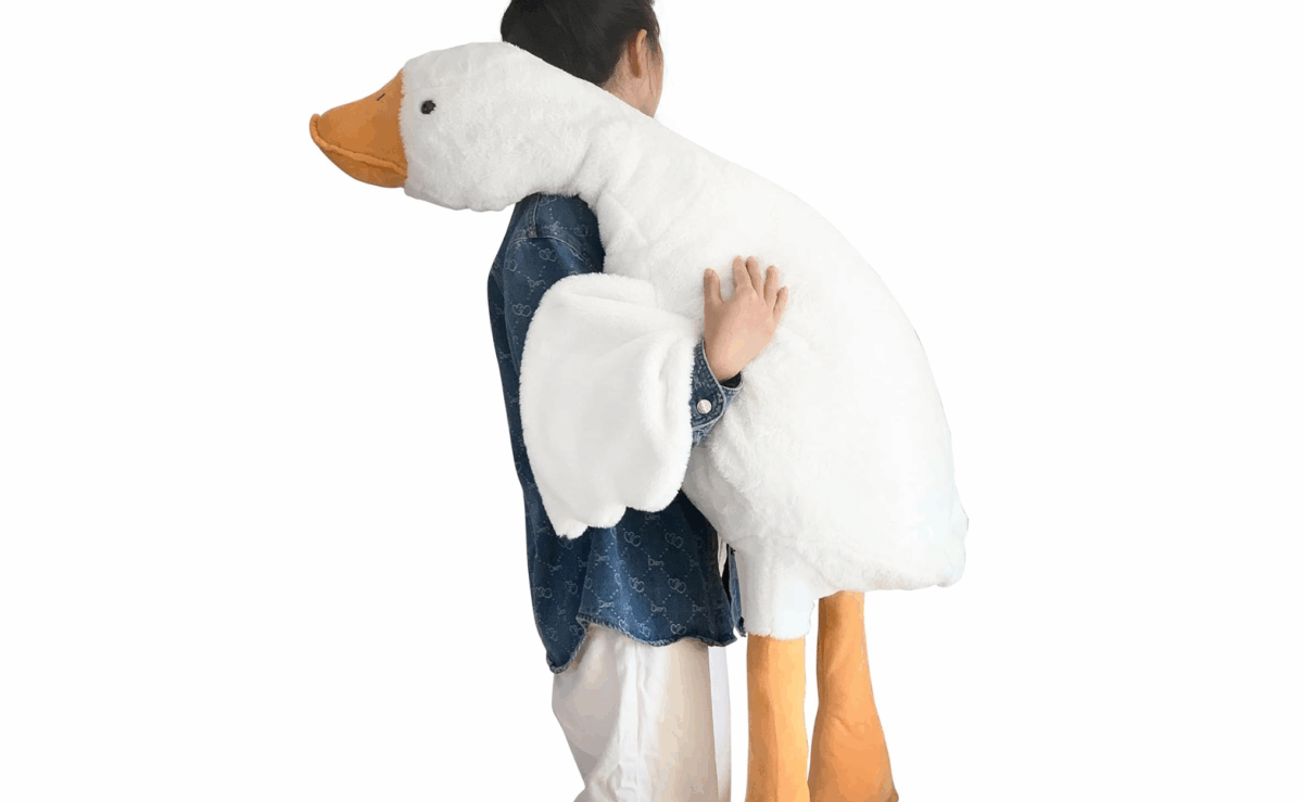 Large white Haengbuk goose plush toy being held in someone’s arms.