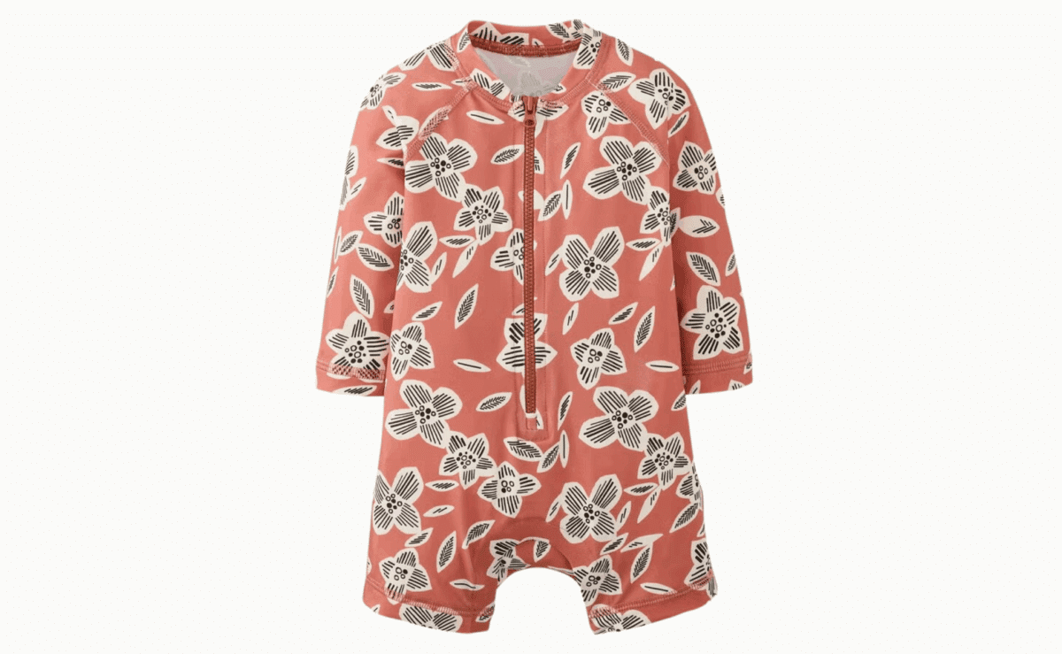 Coral floral long-sleeve rashguard baby swimsuit with white and black flower pattern.