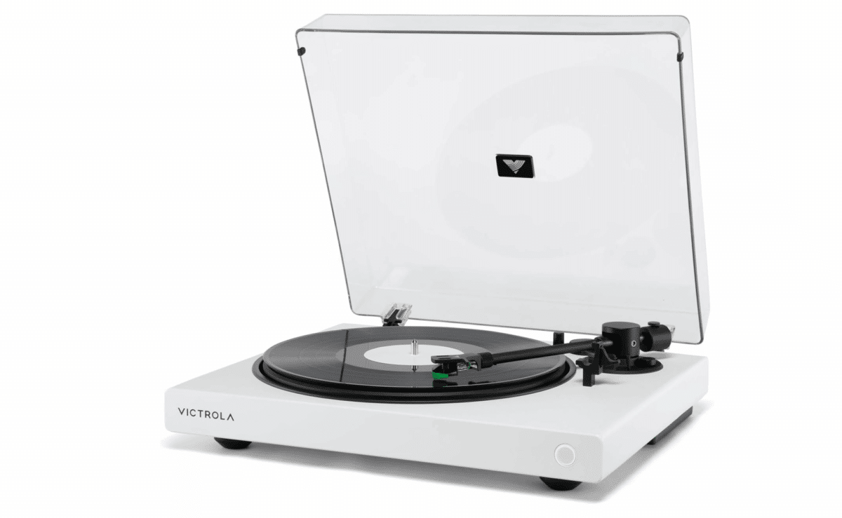 White Victrola Wave Bluetooth turntable with clear lid and vinyl record playing.