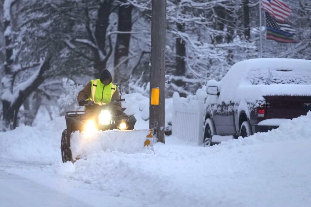Man plowing snow covered driveway