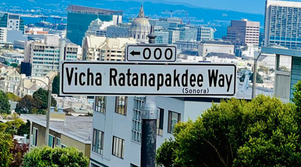 Sign with street name, residential buildings in background