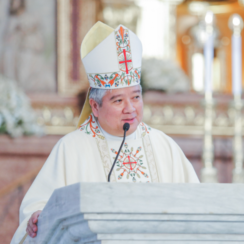 Archbishop Socrates Villegas wearing bishop's white robe in pulpit