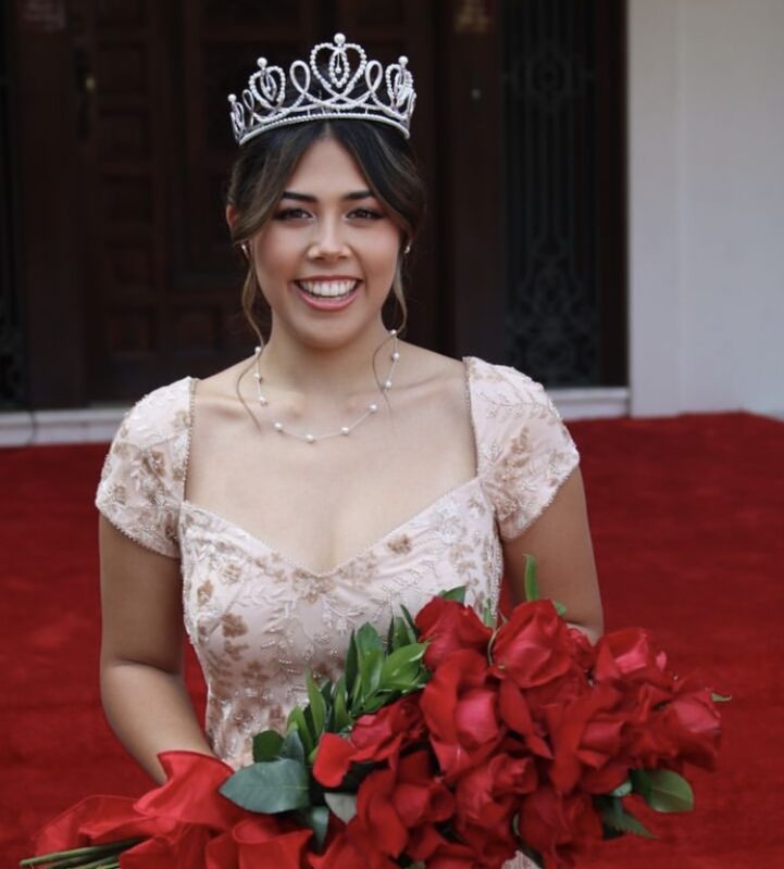 Trinity Dela Cruz wearing a crown and holding a bouquet of roses