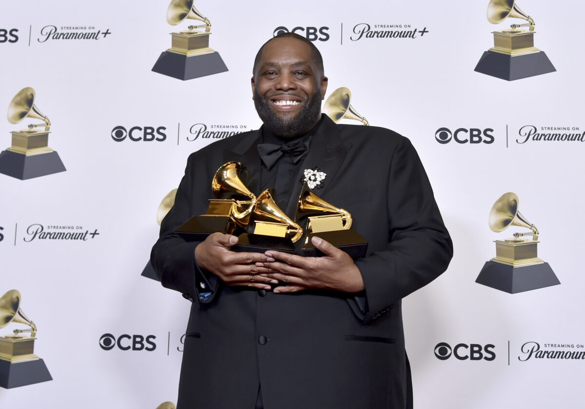 Killer Mike holding Grammy trophies