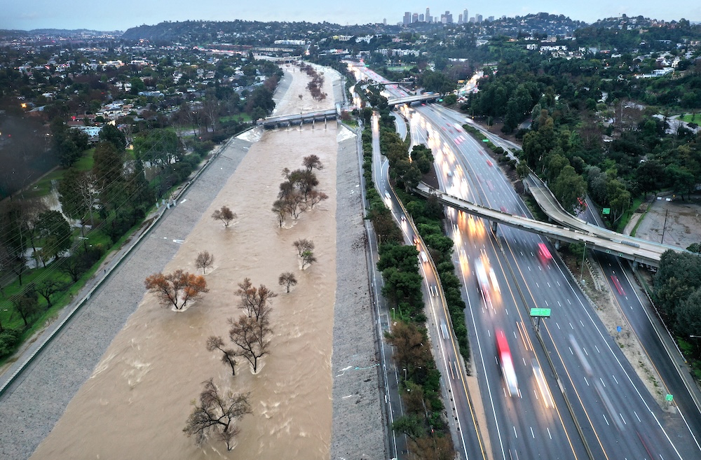 LOS ANGELES, CALIFORNIA - FEBRUARY 05: An aerial view of the Los Angeles River swollen by storm runoff as a powerful long-duration atmospheric river storm, the second in less than a week, continues to impact Southern California on February 5, 2024 in Los Angeles, California. Nearly seven inches of rain have fallen in downtown Los Angeles during the storm, about half the average yearly total. The storm is delivering widespread flooding, landslides and power outages while dropping heavy rain and snow across the region. Mario Tama/Getty Images/AFP (Photo by MARIO TAMA / GETTY IMAGES NORTH AMERICA / Getty Images via AFP)