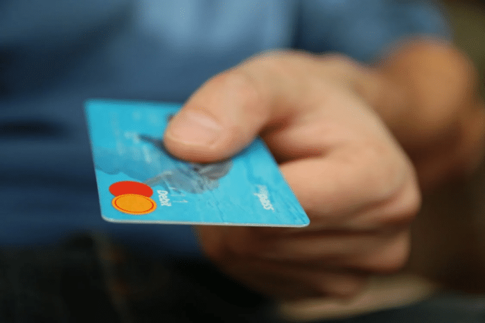 Hand holding a credit card, symbolizing debt management and financial transactions.