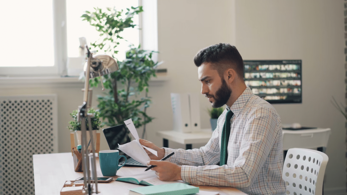 Man working at a desk with financial documents, symbolizing debt planning and management.