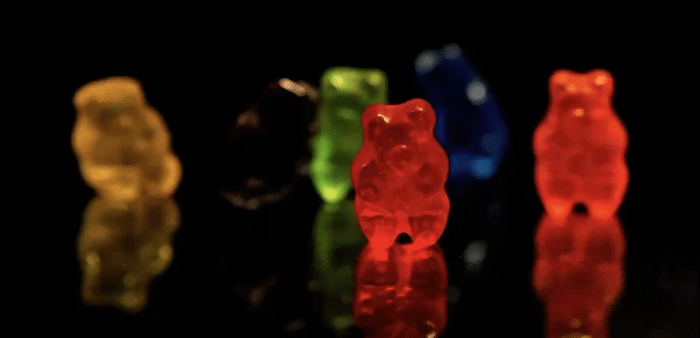 A colorful assortment of HHC gummies displayed on a clean surface, with soft lighting highlighting their texture and vibrant colors, symbolizing wellness and relaxation.