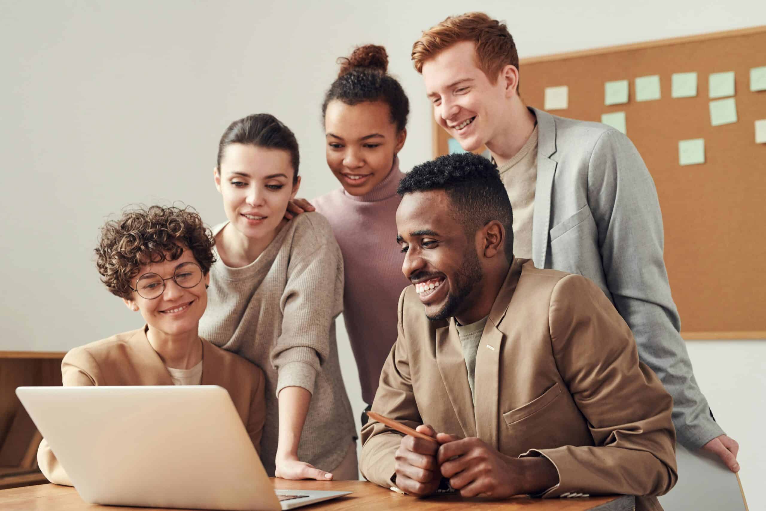 A collaborative team of professionals gathered around a laptop, symbolizing SunStar Debt's commitment to customer satisfaction and personalized debt relief strategies."