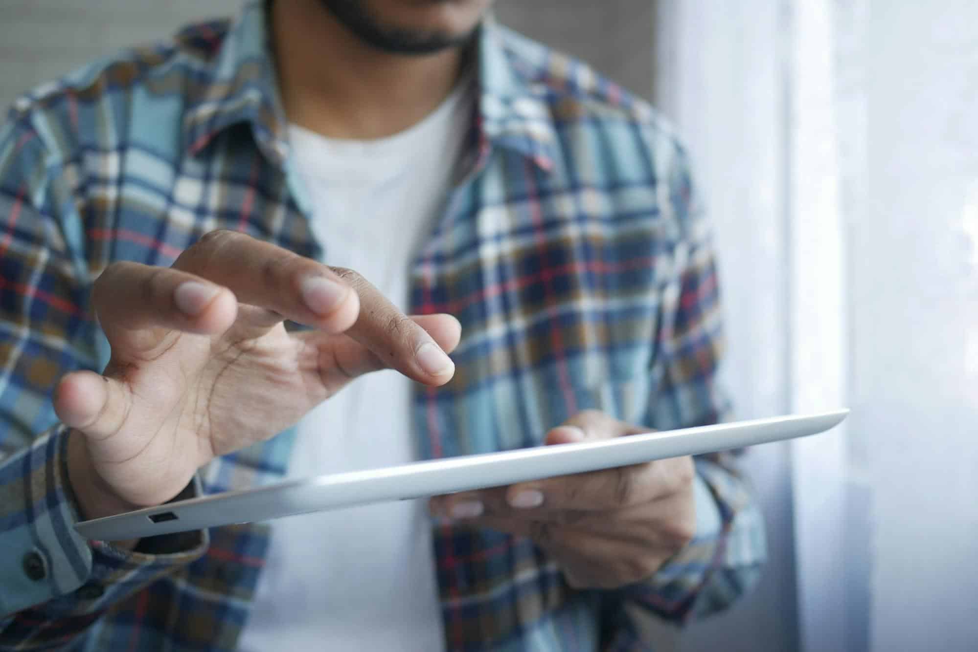 Close-up of a person using a digital tablet, representing customers reviewing and reporting issues or concerns with Republic Finance’s loan services online