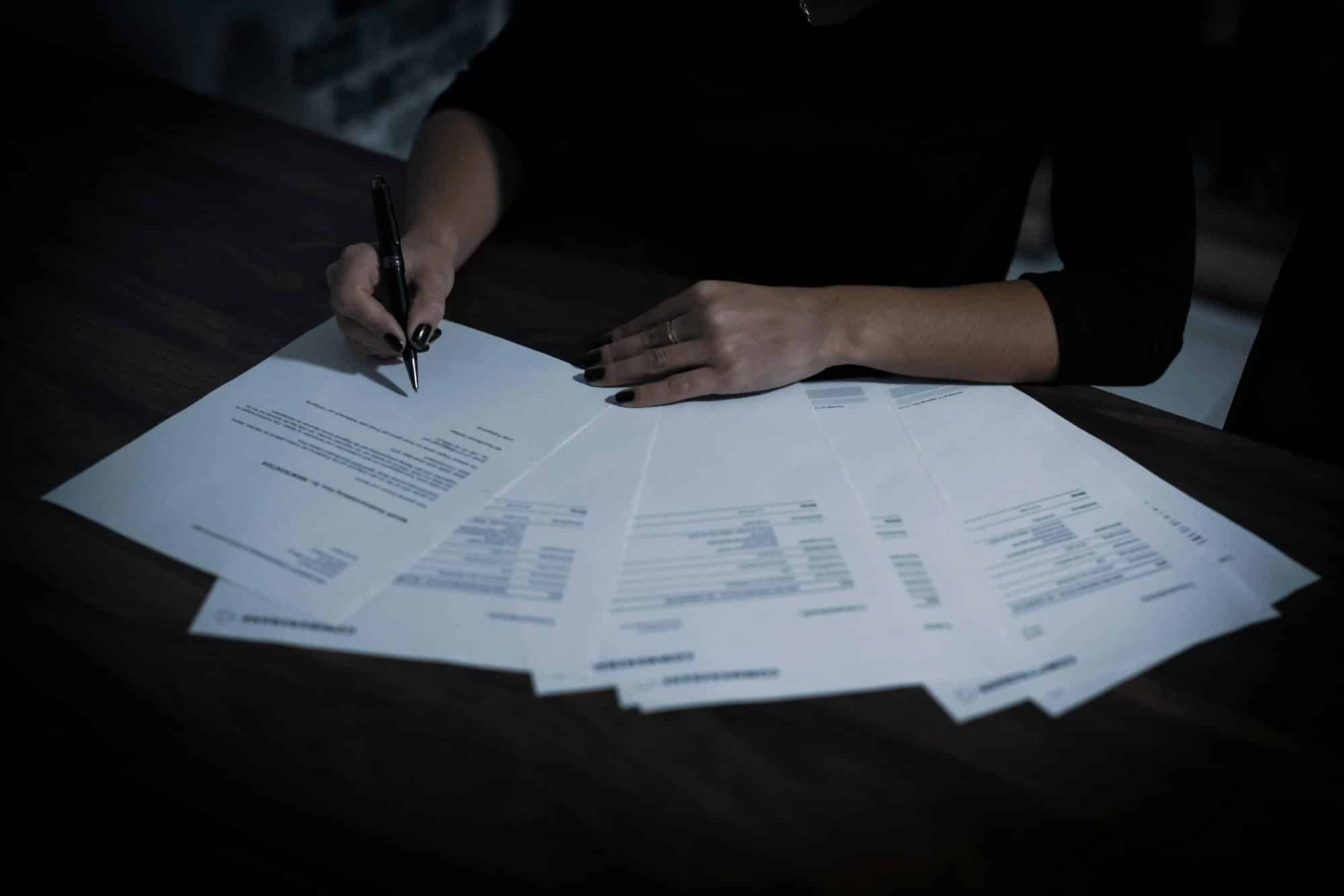 Person reviewing financial documents and loan terms, representing Fig Loans fees, interest rates, and repayment conditions.