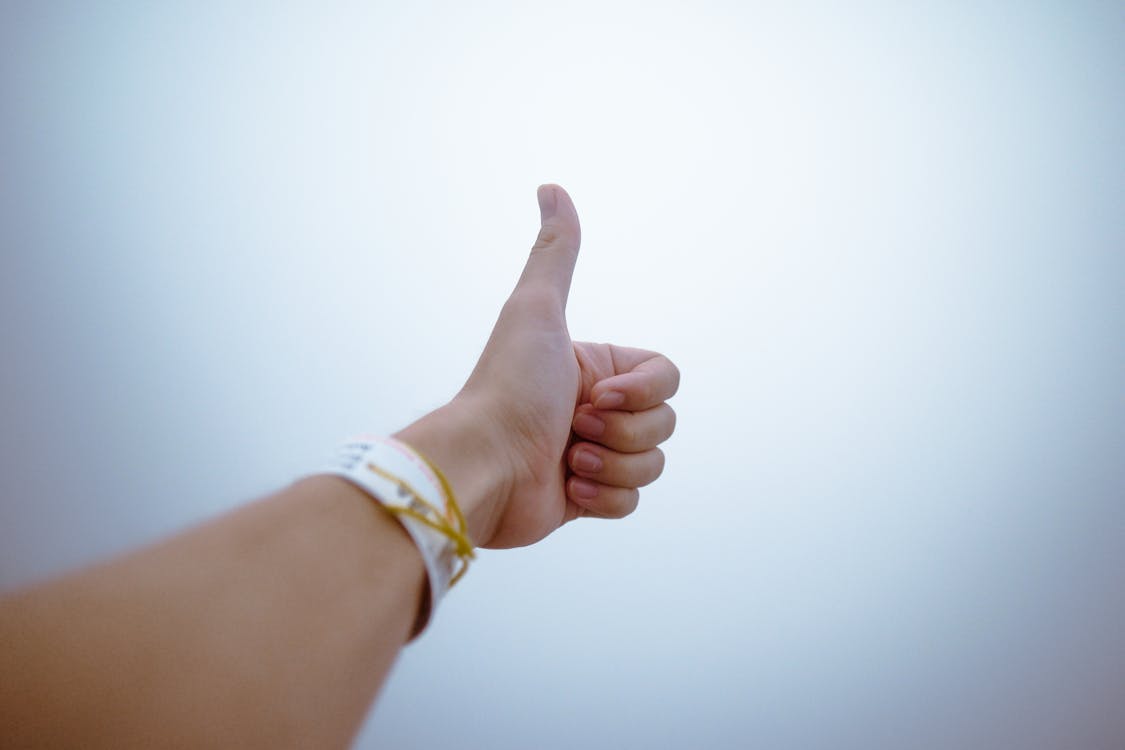 Person giving a thumbs-up gesture, symbolizing the benefits and positive aspects of choosing Fig Loans.