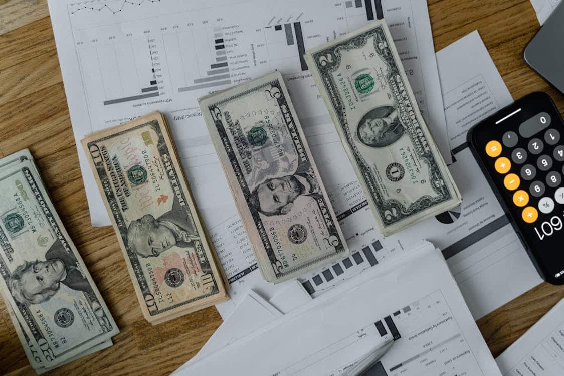 U.S. dollar bills, calculator, and financial documents representing the comparison between Fig Loans and payday loans.