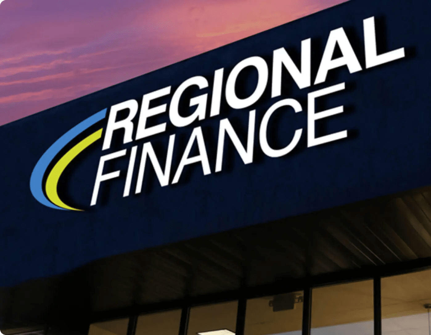 Exterior sign of a Regional Finance branch at sunset, representing the company's in-person loan services for subprime borrowers.