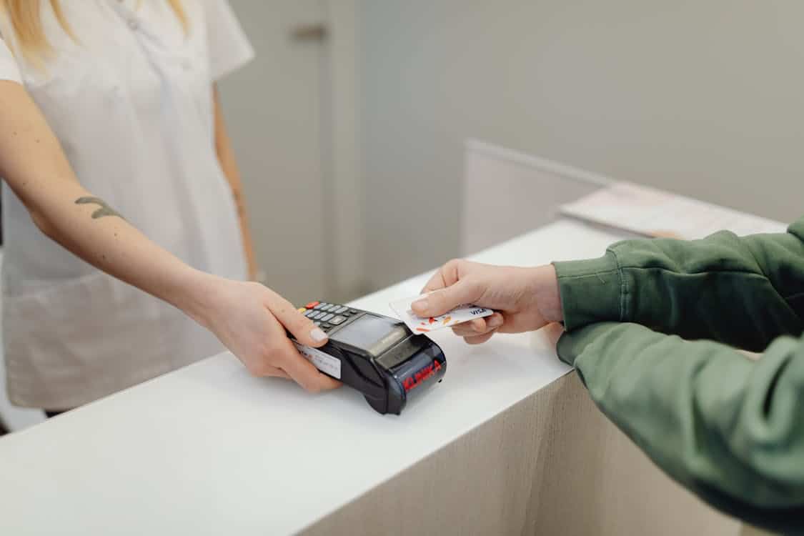 Customer making a card payment at a counter, illustrating how to secure the best mortgage rates with loanDepot by managing credit score, debt-to-income ratio, and loan terms.