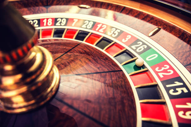 Close-up of a roulette wheel with the ball landing on green zero