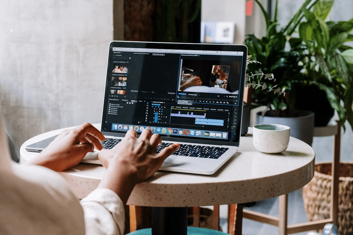 Close-up of a person editing video on a laptop using professional software.