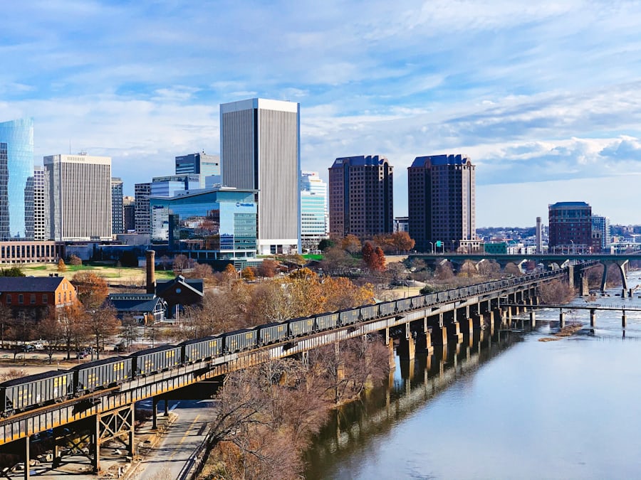 Downtown Richmond, Virginia skyline with modern office buildings, bridges, and the James River in the foreground.