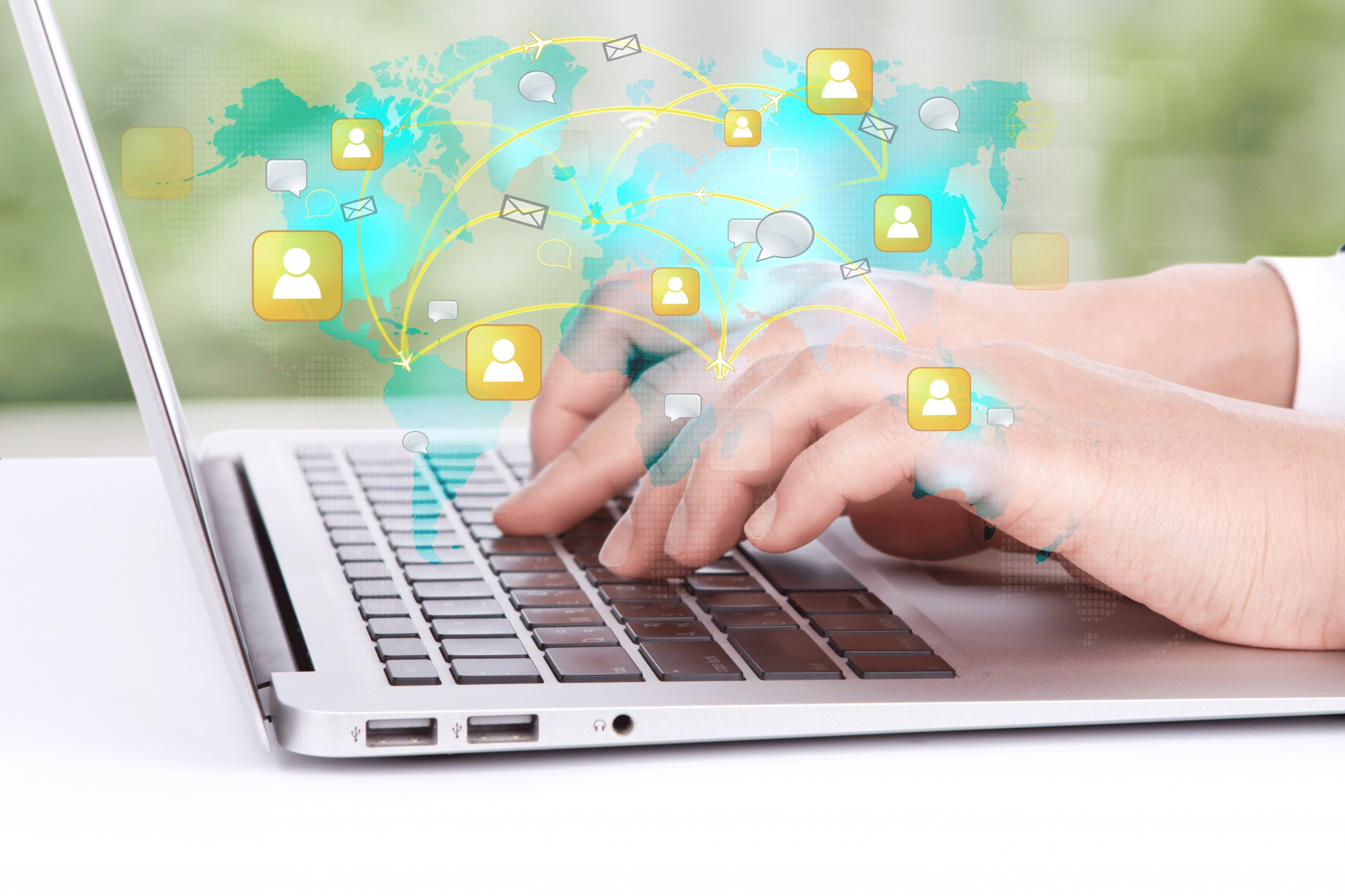 Hands typing on a laptop with a digital overlay showing a world map and connected icons representing social media profiles and communication.